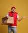 Emotional courier with damaged cardboard box on background. Poor quality delivery service