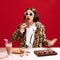 Emotional, eccentric woman in sunglasses and animal print coat, dj on party, playing music and eating chocolate against