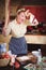 Emotional expressive woman in the kitchen. In the hands holding tools for cooking food