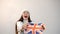 Emotional girl shakes national United Kingdom flag in studio