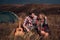 Emotional happy young loving couple on picnic hugging outside in free alternative vacation camping over mountains.