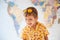 Emotional laughing kid with sunglasses on head on world map background