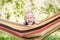 Emotional little boy in hammock in summer garden