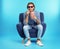 Emotional man with 3D glasses and popcorn sitting in armchair during cinema show