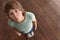 Emotional overweight boy standing on floor scales, above view. Space for text