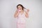 Emotional plump woman in pink dress talking and gossips on the Shoe like on the phone on a white Studio background