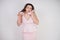 Emotional plump woman in pink dress talking and gossips on the Shoe like on the phone on a white Studio background