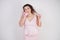 Emotional plump woman in pink dress talking and gossips on the Shoe like on the phone on a white Studio background