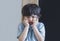 Emotional portrait Angry aggressive kid,Child standing  alone with upset or sad face, Little trouble boy covered his face with
