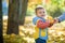 Emotional portrait of a happy and cheerful little boy laughing. yellow flying maple leaves while walking in the autumn park. Happy