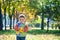 Emotional portrait of a happy and cheerful little boy laughing. yellow flying maple leaves while walking in the autumn park. Happy