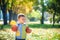 Emotional portrait of a happy and cheerful little boy laughing. yellow flying maple leaves while walking in the autumn park. Happy