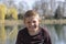 Emotional portrait of a kind and happy little boy looking with a smile, lake at the background