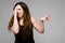 Emotional pretty confident angry plus size model standing in studio showing disgust sign on gray background