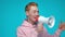 Emotional redhead man in pink hoodie shouting in megaphone