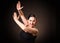 Emotional smiling woman with hair up in a bun in black dress dancing flamenco and do characteristic movements by hands