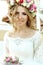 Emotional touched beautiful blonde bride in white dress in wreath with make-up close-up