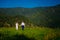 Emotional wedding shot of the happy glamour newlywed couple walking on meadow in wild nature. Beautiful nature view