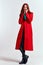 Emotional woman in a red coat and with a hat in full growth on a light background black boots pose model