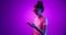 Emotional young girl in eyewear using phone, watching funny video isolated on purple background in neon light, filter