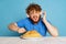 Emotional young hairy red-bearded man tasting large portion of noodles, pasta isolated on blue studio background.