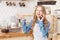 Emotional young lady in apron gesturing during phone talk