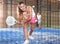 Emotional young sportswoman playing padel tennis on indoor court