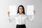 Emotional young woman with blank sheets of paper on light background