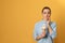 Emotional young woman with sensitive teeth and ice cream on color background