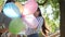 Emotions in sunny day, joyful female with colorful balloons congratulates friend happy birthday in park