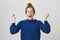 Emotive girl celebrates victory of her soccer team. Studio shot of expressive attractive woman with red hair and