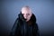 Emotive photo of a bald woman in a black raincoat