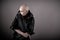 Emotive photo of a bald woman in a black raincoat