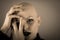 Emotive portrait of a bald woman while covering her face