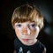 Emotive portrait of red-haired freckled boy, childhood concept