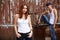 Emotive portrait of a stylish couple in jeans standing near wood