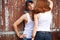 Emotive portrait of a stylish couple in jeans standing near wood