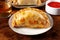 Empanada close-up with a red salsa and a glass of wine