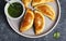 Empanadas with chimichuri sauce. Traditional Latin American cuisine.