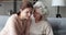 Empathic senior mother comforting sad crying young adult daughter