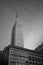 the empire state building and a plane flying by in black and white