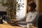 An employee of an accounting firm completes outstanding documents. She works alone at home. She sits at her desk writing