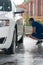 The employee is engaged in washing the car, at the car wash