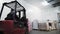 Employee on forklift truck takes boxes stack in warehouse