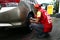 Employee at a gasoline station check the pressure and inflate the tire of a customerâ€™s car