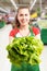Employee at grocery store holding lettuce