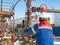 An employee of an oil company performs work in an oil field well.