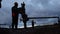 An employee in overalls and a helmet is carrying out repairs and maintenance of an oil well. Silhouette on the