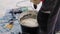 Employee prepares wet mix in bucket at construction closeup