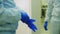 Employee puts on blue rubber gloves in plant workshop locker